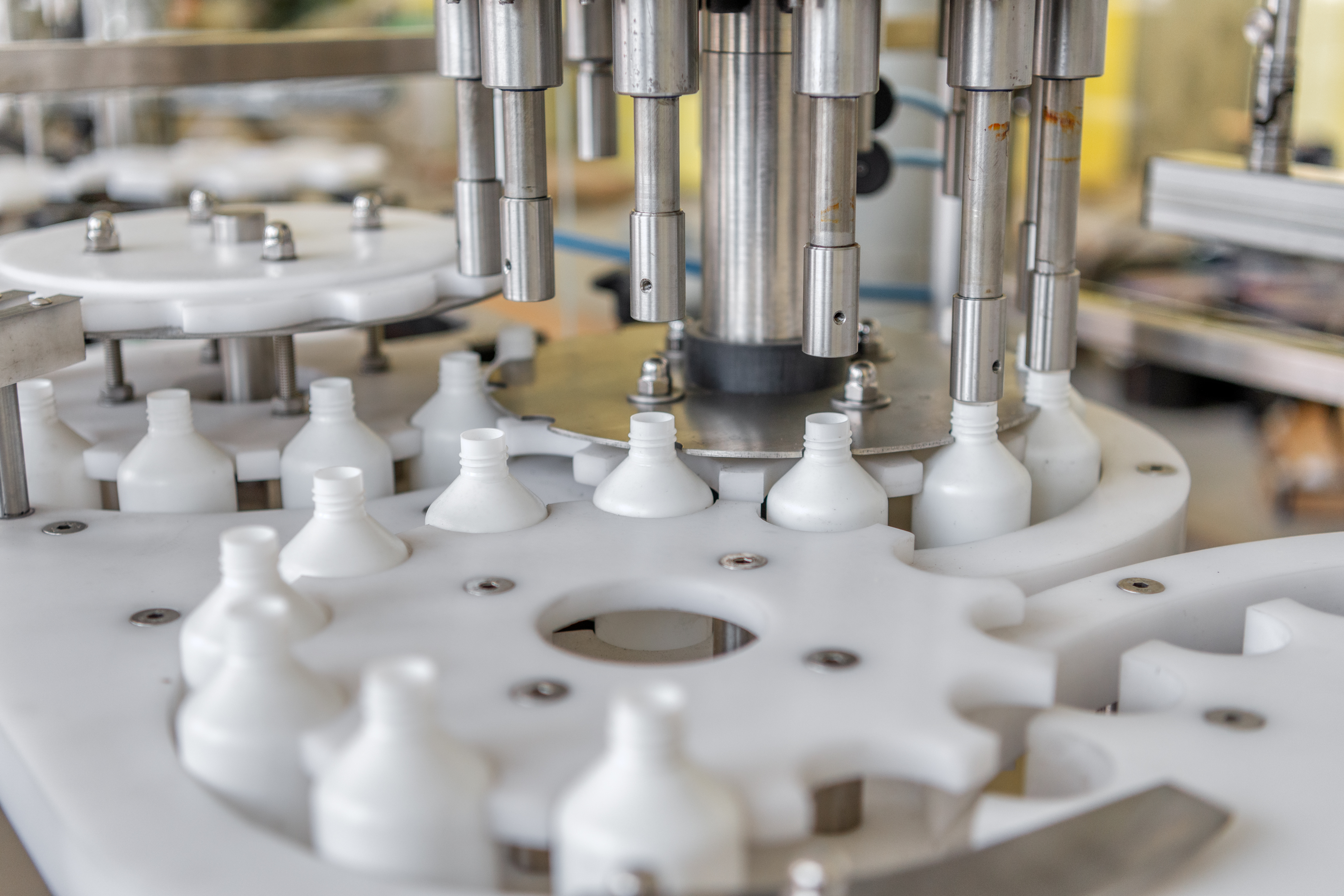 Rotary capping system — stainless capping heads over a star-wheel of bottles